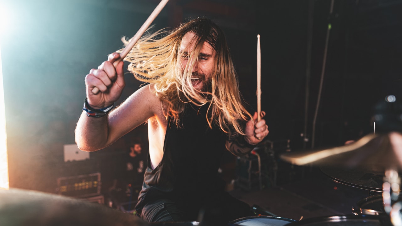 Drummer performing live in a studio setting