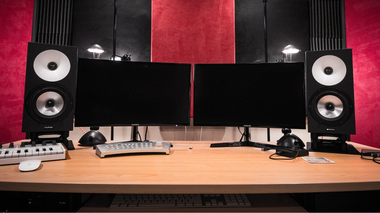 Home recording studio workstation with dual monitors and studio speakers