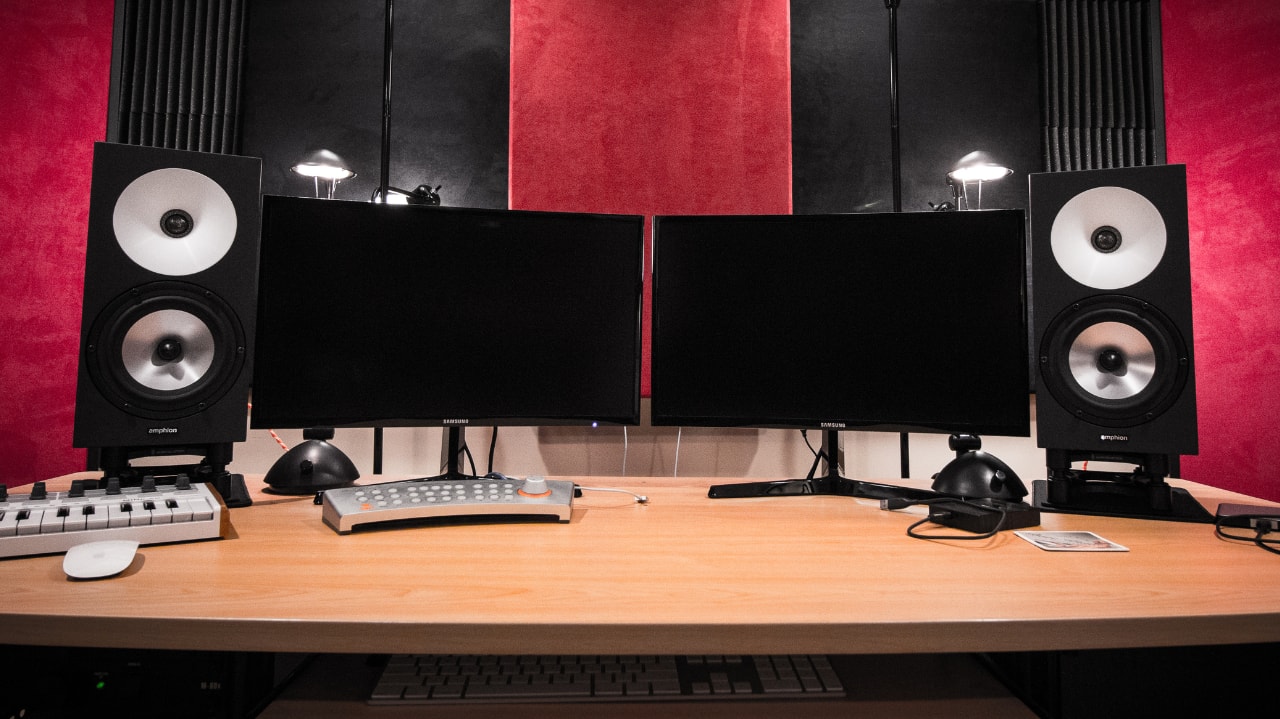 Home recording studio workstation with dual monitors and studio speakers